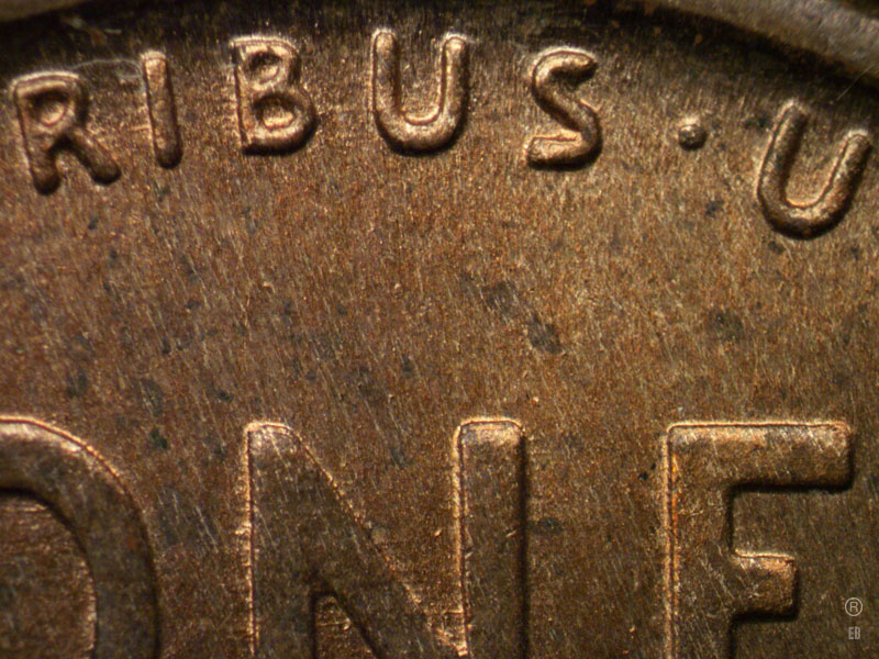 Die-stage B marker on 1909P•1DR•007 showing Center of the upper section of the reverse design showing dice scratches running through Pluribus.