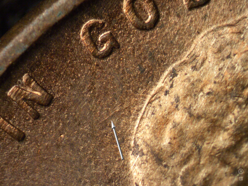 Die-stage B marker on 1909P•1DR•007 showing A die scratch shows behind the head.
