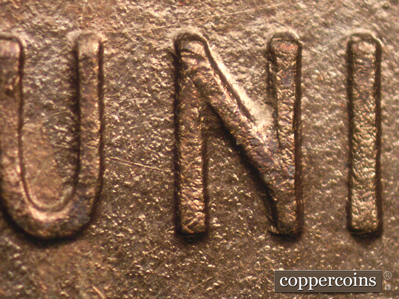 Die-stage A marker on 1909P•1DR•008P showing A diagonal NE-SW die scratch connects the UN of UNITED.