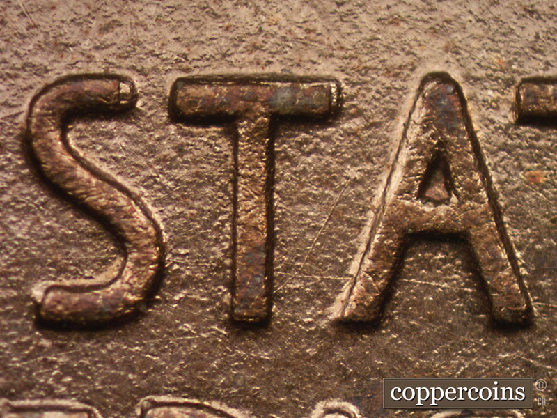 Die-stage A marker on 1909P•1DR•008P showing Die scratch between the T and A of States and one that runs from the lower T through the bottom of the A.