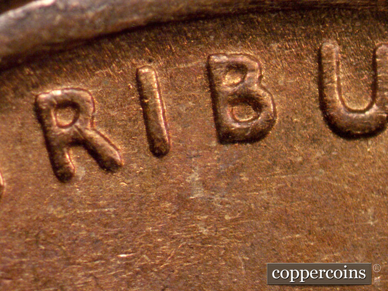 Die-stage B marker on 1909P•1DR•009 showing Thickness in the U of PLURIBUS.