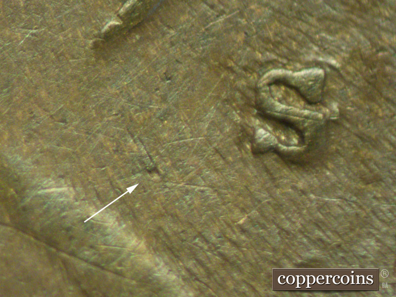 Die-stage C marker on 1909S•1MM•002 showing What is apparently a die scratch or die dot shows to the southwest of the mint mark close to the vest.