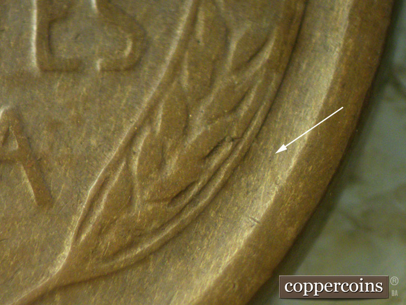 Die-stage C marker on 1909S•1MM•002 showing A die crack shows outside the right wheat grains toward the rim.