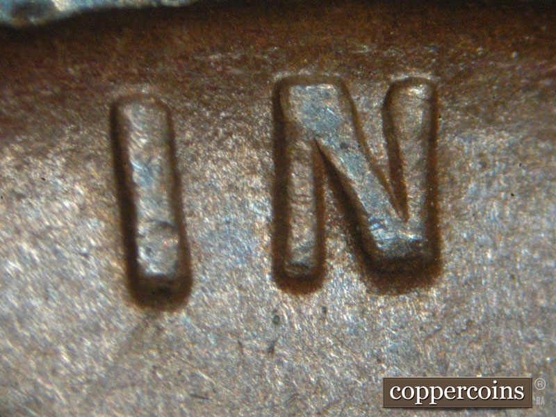 Die-stage C marker on 1911D•1MM•001 showing Very thin horizontal die scratches through the letters I and N of IN.
