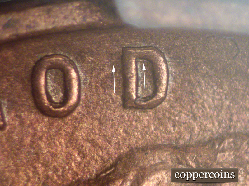 Die-stage A marker on 1911D•1MM•002 showing Die scratch through upper part of D in GOD of motto.