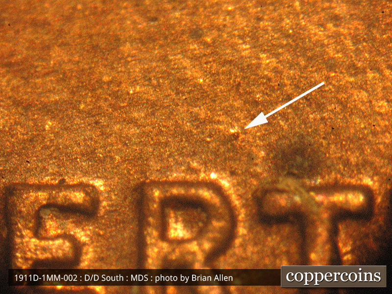Die-stage B marker on 1911D•1MM•002 showing a die dot shows above the RT of liberty.