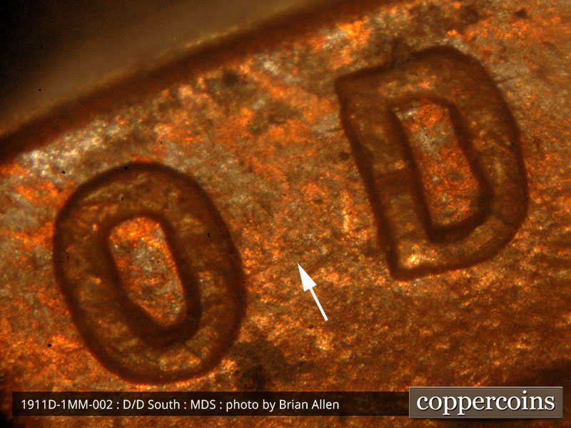 Die-stage B marker on 1911D•1MM•002 showing Concentric die scratches show between the O and D of GOD.