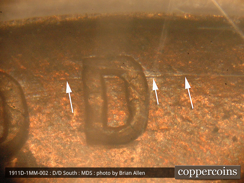 Die-stage B marker on 1911D•1MM•002 showing Concentric die scratches show behind the top of the D of God.