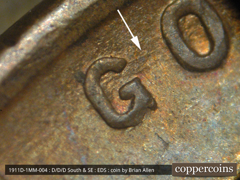 Die-stage A marker on 1911D•1MM•004 showing A die scratch extends toward the east from the upper curve of the G of GOD.