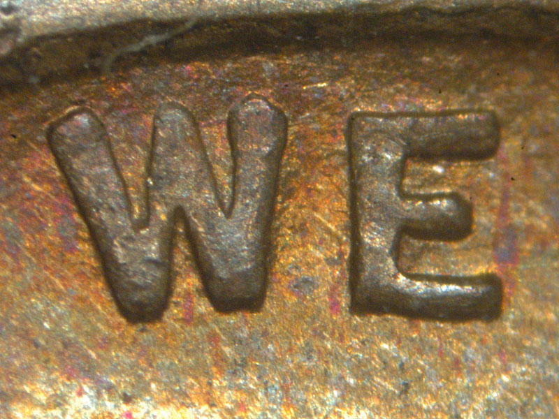 Die-stage A marker on 1911D•1MM•004 showing Area of WE showing very light die scratches along the inside of the rim.