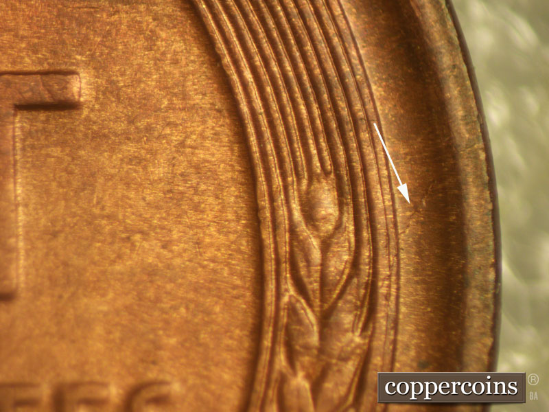 Die-stage C marker on 1911D•1MM•004 showing A small die crack runs from the upper wheat grains in the right wheat to the rim.