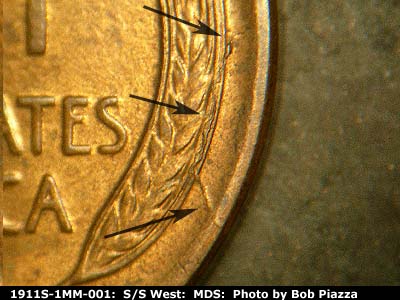Die-stage B marker on 1911S•1MM•001 showing Die crack running through the right wheat rim to rim.