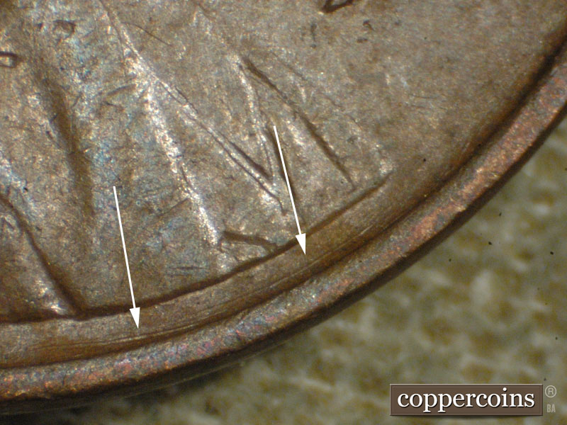 Die-stage A marker on 1917P•1DO•002 showing Concentric die scratch between lapel and rim.