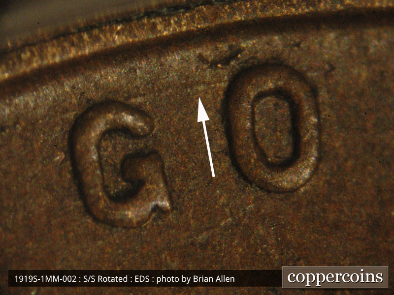 Die-stage A marker on 1919S•1MM•002 showing Die gougeconnecting the g and o of God.