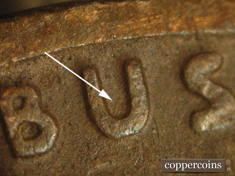 Die-stage C marker on 1927D•1MM•003 showing A northeast to southwest die scratch can be seen inside the U in PLURIBUS.