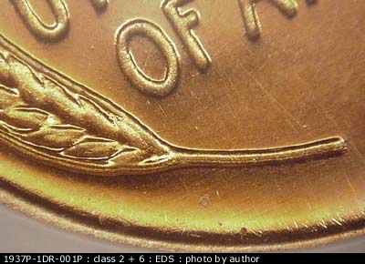 Die-stage A marker on 1937P•1DR•001P showing Doubling shows on the lower left of the design as well. Dice scratches show running north and south through most of t….