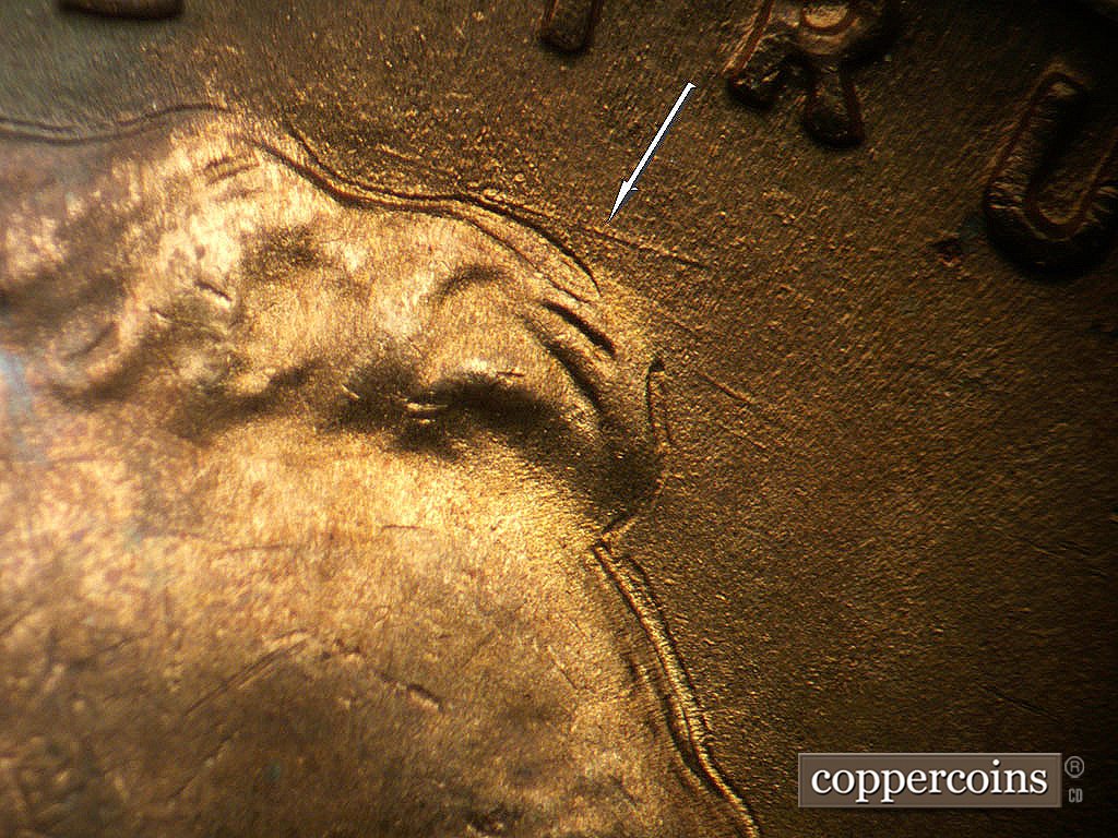 Die-stage B marker on 1942P•1DR•003 showing ESE die scratch above front of hair.