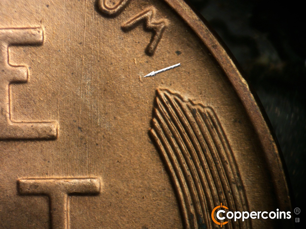 Die-stage A marker on 1942S•1DO•004 showing N/S die scratches east of E in ONE. Die gouges under M in UNUM.