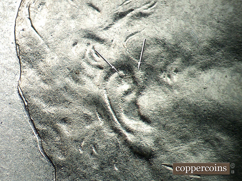 Die-stage A marker on 1943P•1DO•031 showing Die chip in ear, ENE die scratch in ear.