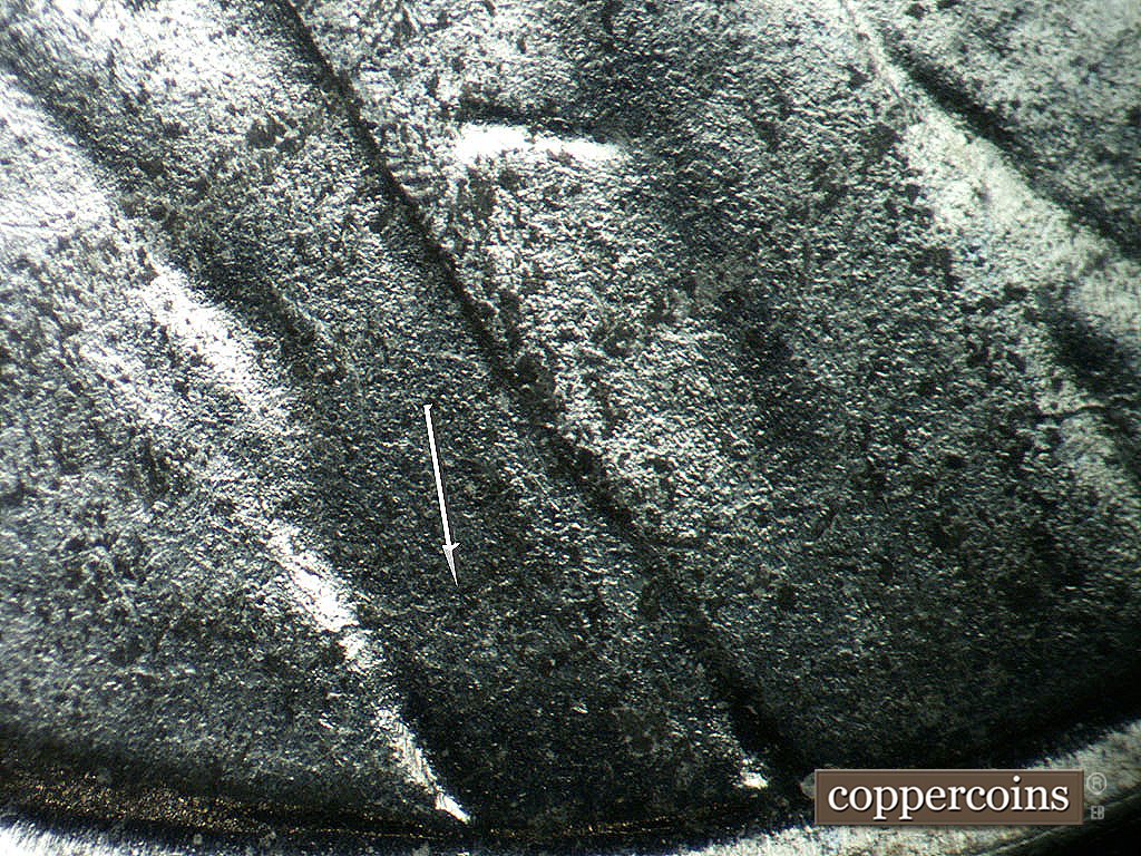 Die-stage B marker on 1943P•1DO•038 showing Die crack across jacket into lapel.