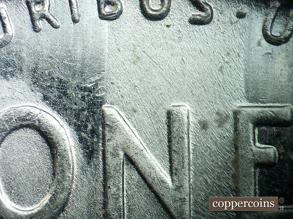 Die-stage B marker on 1943P•1DO•039 showing Feeder finger marks near O in ONE.