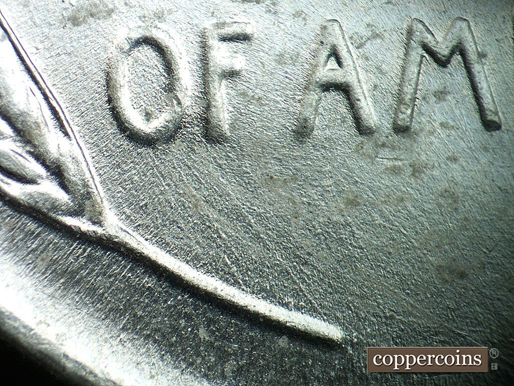 Die-stage B marker on 1943P•1DO•039 showing SE die scratch from O ijn OF to left wheat stem tip.