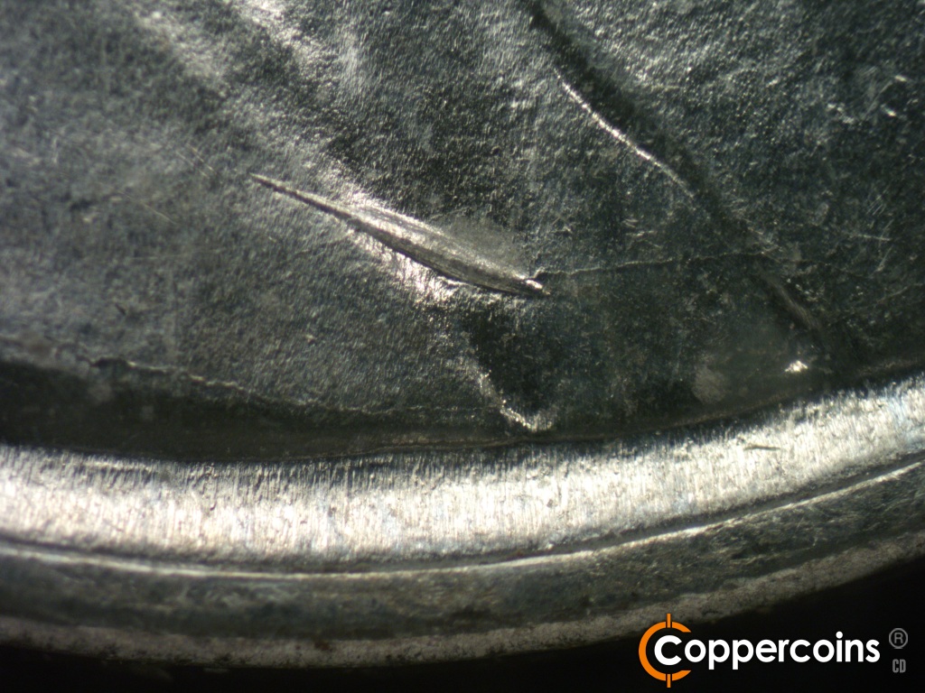 Die-stage B marker on 1943P•1DO•040 showing A very heavy and long die gouge shows over the lower shoulder fold.