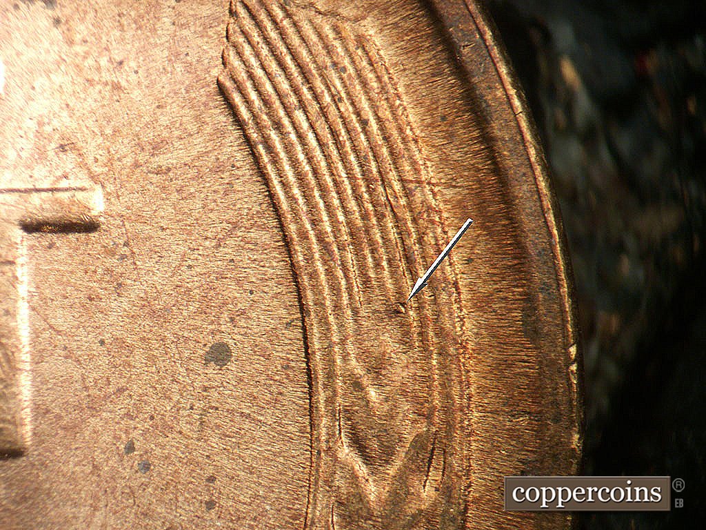 Die-stage B marker on 1944D•1MM•014 showing A die dot shows just above the top grain of wheat in the right wheat stalk.