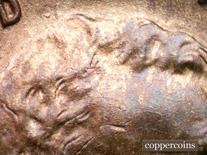 Die-stage A marker on 1944D•1OM•002 showing Concentric die scratches across forehead. Die crack starting to form in hair.
