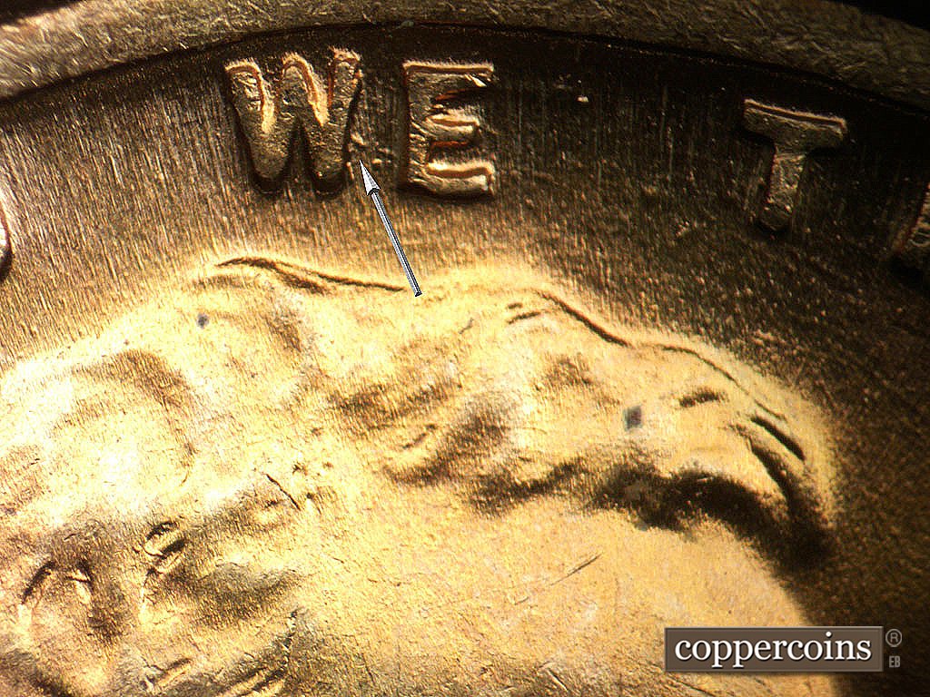 Die-stage B marker on 1944P•1DO•038 showing Die gouge from W in WE.