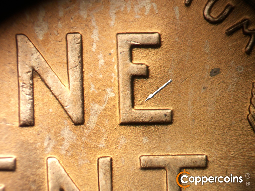 Die-stage B marker on 1945P•1DO•013 showing Die gouge in lower inside of E in ONE.