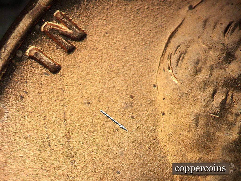 Die-stage A marker on 1945P•1DO•023 showing SE die scratch from back of hair.