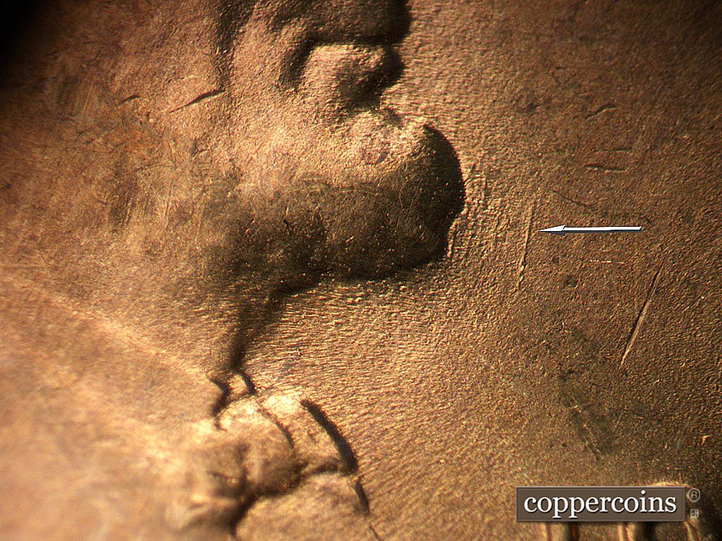 Die-stage B marker on 1946D•1MM•077 showing N/S die scratch in front of chin.