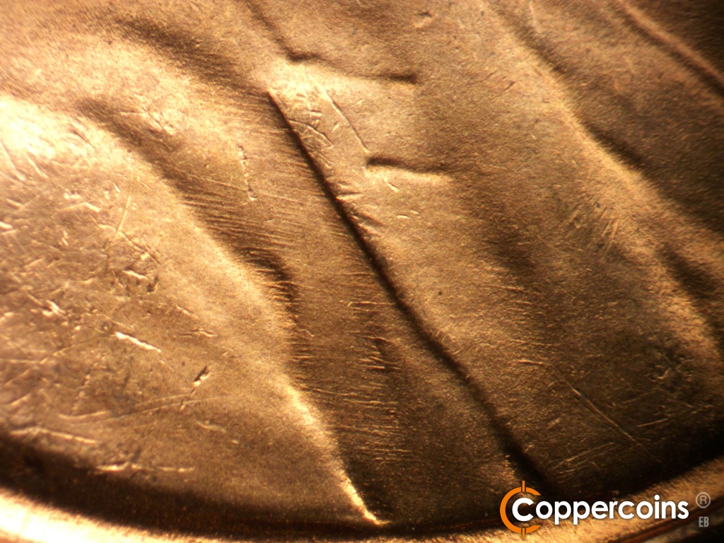 Die-stage B marker on 1948D•1MM•010 showing Numerous die scratches show on the coat.