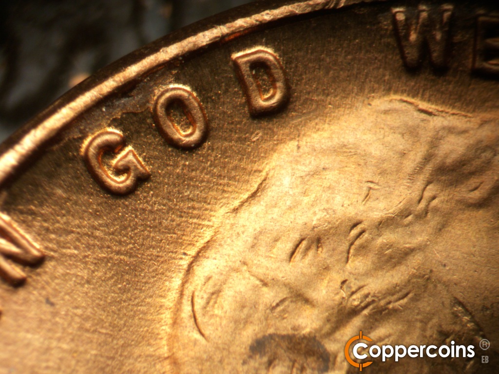 Die-stage B marker on 1948D•1MM•010 showing WNW die scratches from back of hair through GOD.