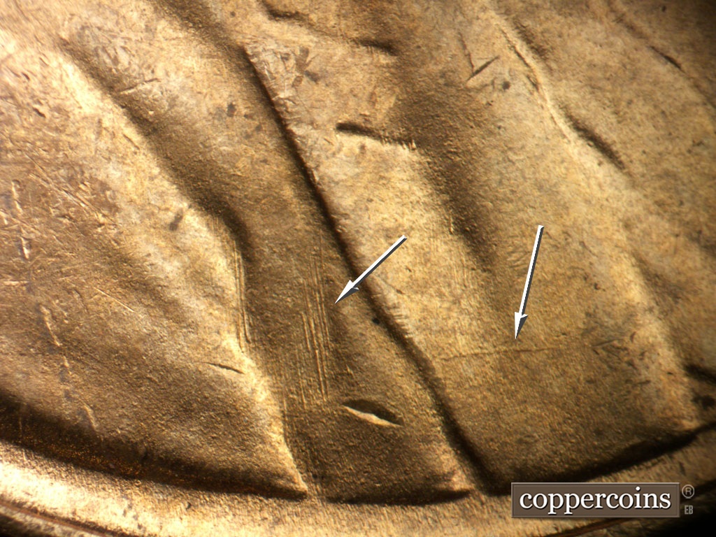 Die-stage B marker on 1948S•1MM•011 showing E/W die crack across lower lapel. N/S die scratches on jacket fold.
