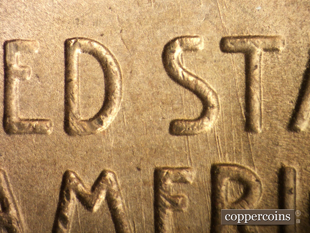 Die-stage B marker on 1948S•1MM•011 showing Heavy die scratches show through ST in STATES down through RI in AMERICA.