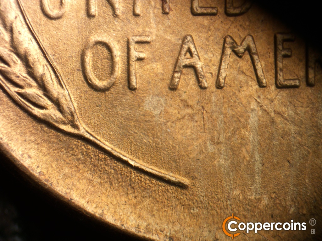 Die-stage B marker on 1948S•1MM•019 showing Worn die scratch under OF and from left wheat stem.