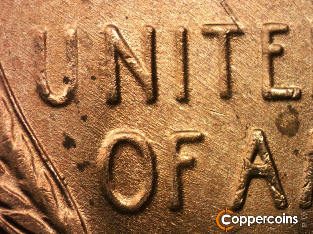 Die-stage B marker on 1950D•1DO•004 showing SE die scratches through UNITED and OF.