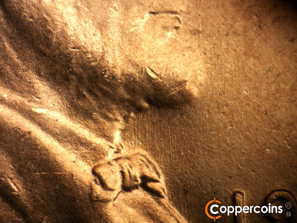 Die-stage B marker on 1950D•1DO•005 showing N/S die scratches in front of throat.