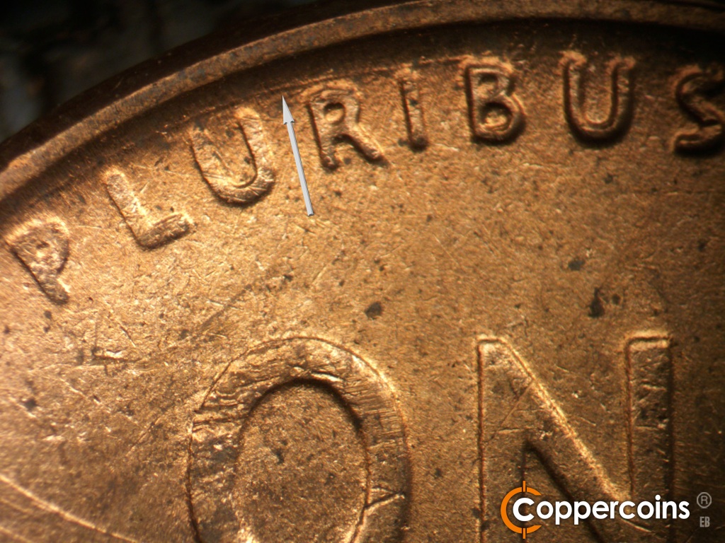 Die-stage B marker on 1950D•1DO•005 showing Concentric die gouge between PLURIBUS and rim.