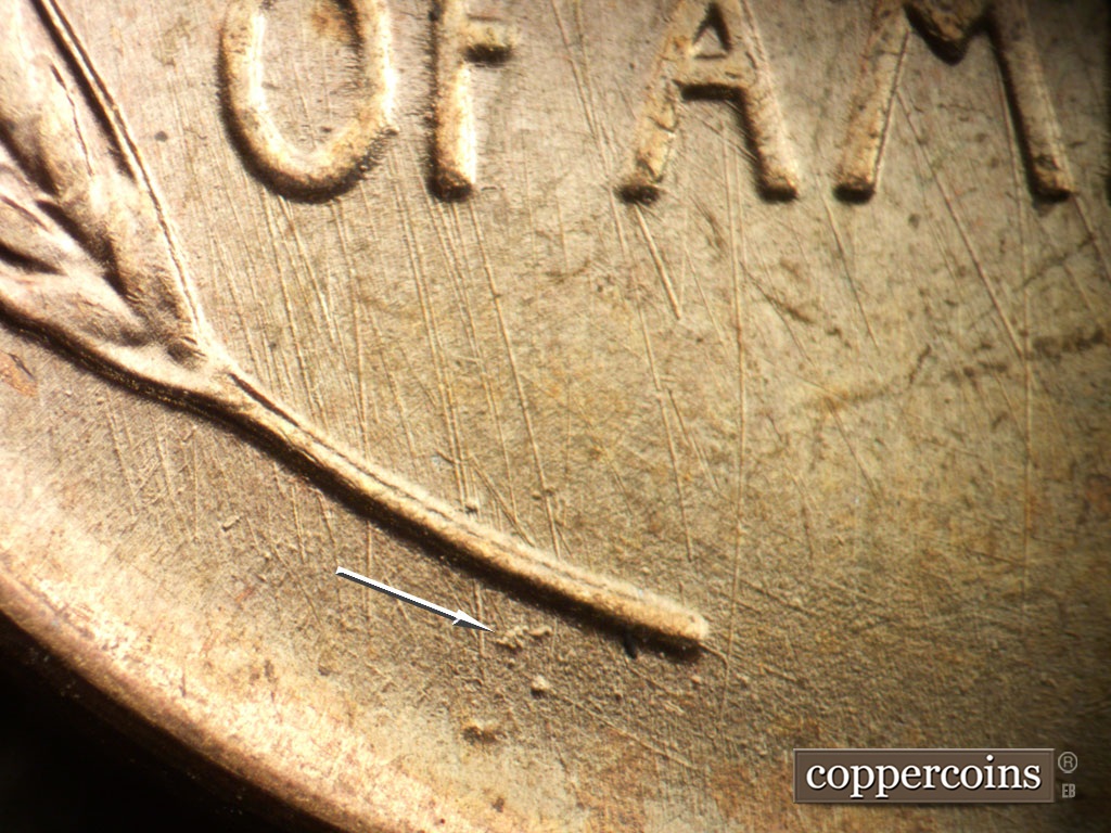 Die-stage A marker on 1950P•1DO•005 showing Die pitting between left wheat stem and rim.