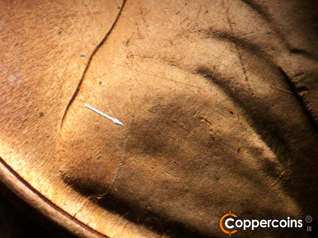 Die-stage B marker on 1951D•1MM•072 showing Die crack from rim into shoulder.