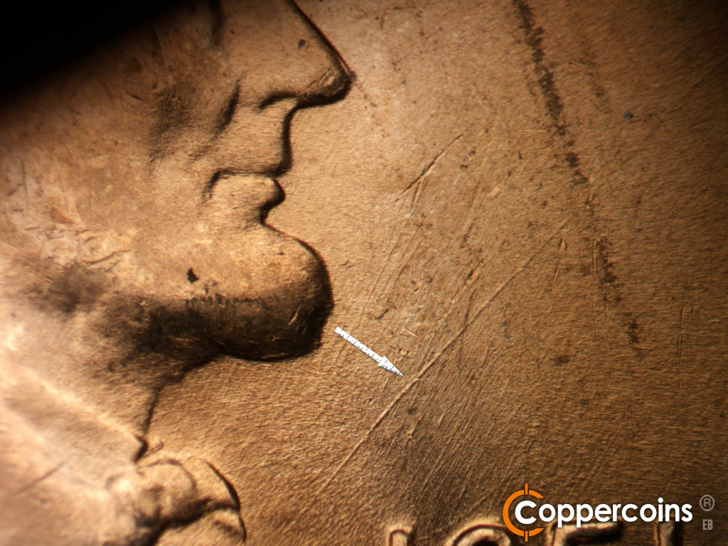 Die-stage B marker on 1951D•1MM•072 showing Heavy die scratch in field east of chin.