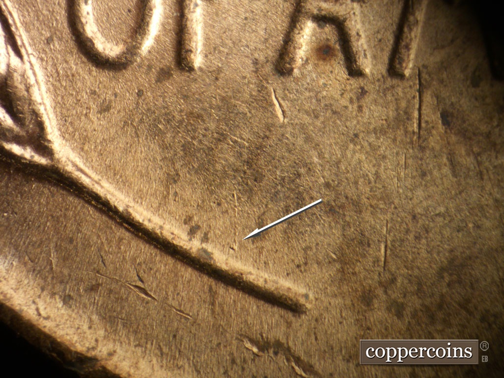 Die-stage B marker on 1952D•1DO•010 showing Die gouge heads north from the left wheat stem.