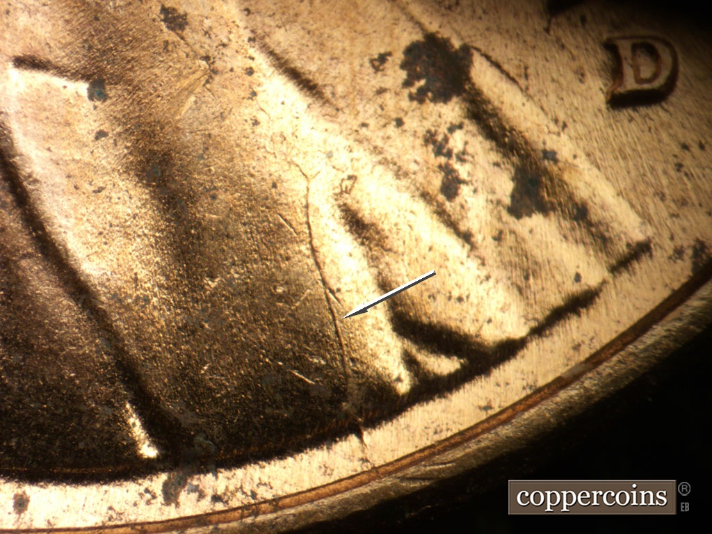 Die-stage C marker on 1952D•1MM•099 showing Die crack from rim up into lapel.