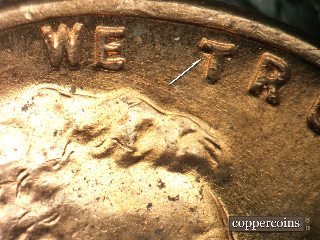 Die-stage B marker on 1952D•1MM•100 showing Die gouge near the top of the first T in TRUST.