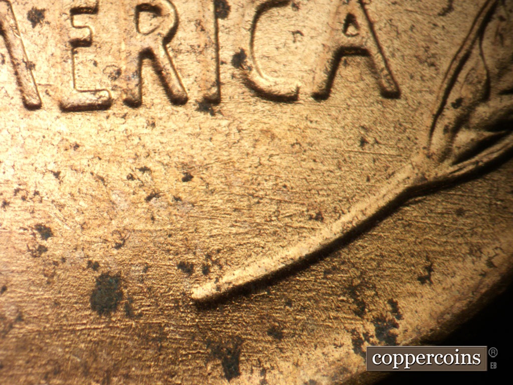 Die-stage B marker on 1952D•1MM•100 showing Die scratches under AMERICA.