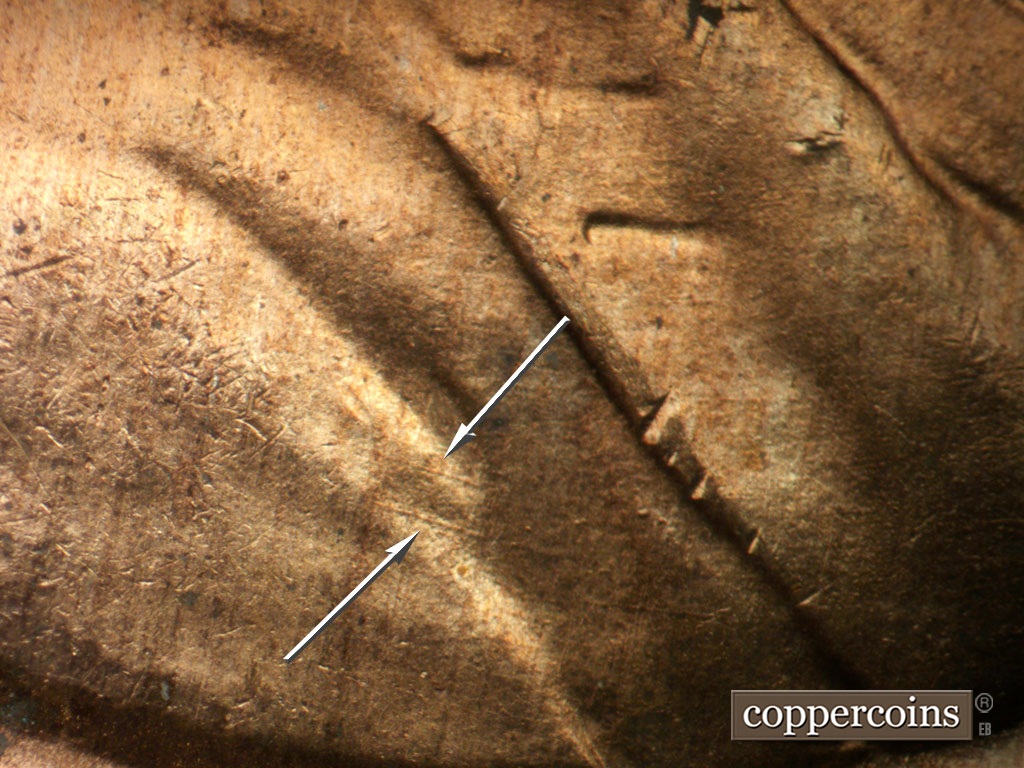 Die-stage A marker on 1953D•1MM•026 showing Pair of ESE die scratches in shoulder fold.