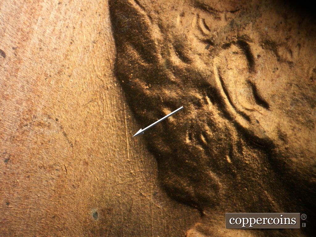 Die-stage A marker on 1953D•1MM•026 showing N/S die scratch from back of hair.